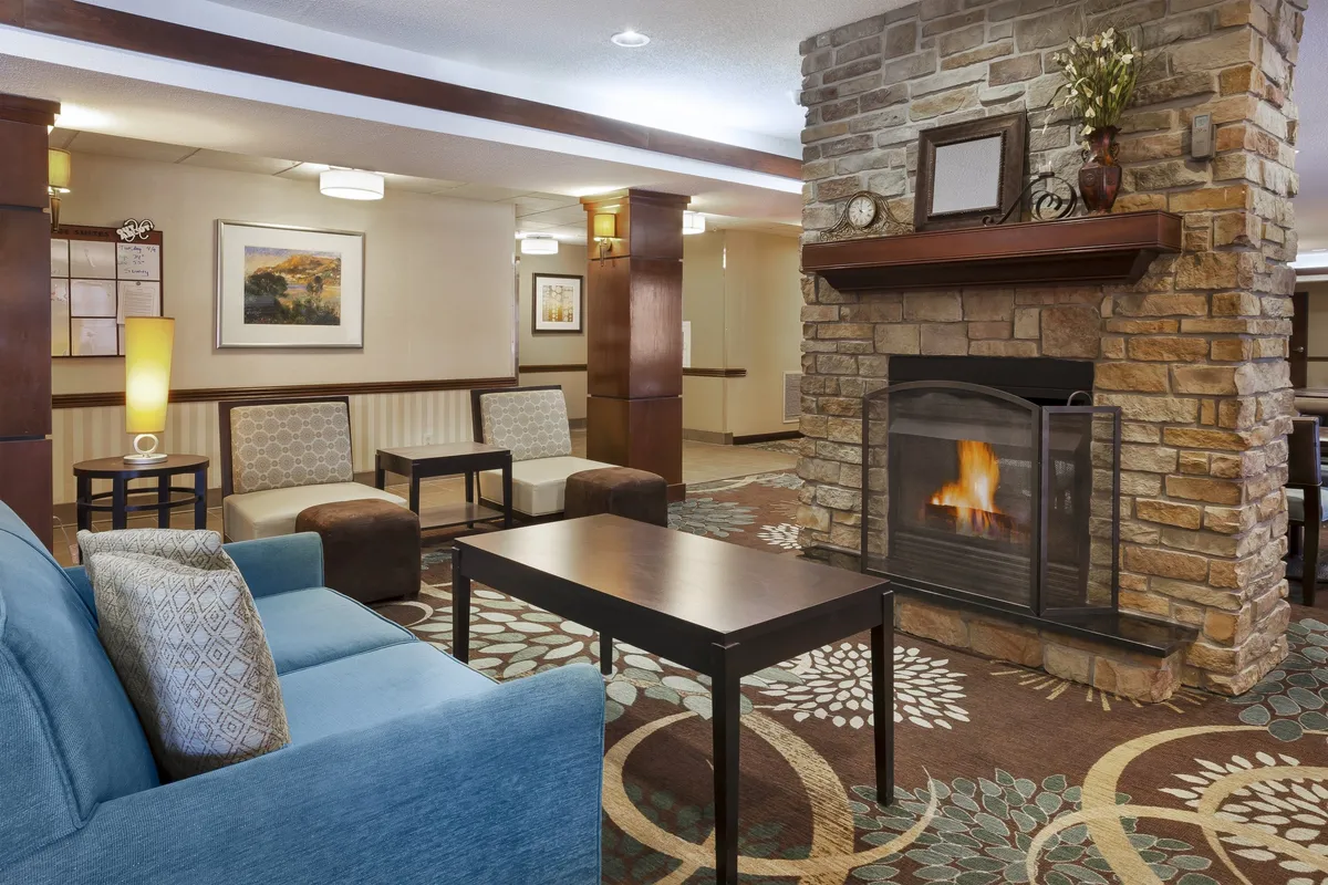 A cozy communal lounge area centered around a fireplace, with comfy seating and decorative artwork. The space is inviting, encouraging guests to relax, socialize, or read by the fire.